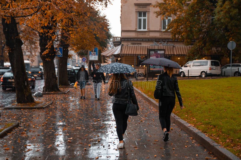 LVIV UKRAINA - September 7, 2018: regn i stad Folk som går med paraplyet arkivbild LVIV UKRAINA - September 7, 2018: regn i stad Folk som går med paraplyet arkivbild