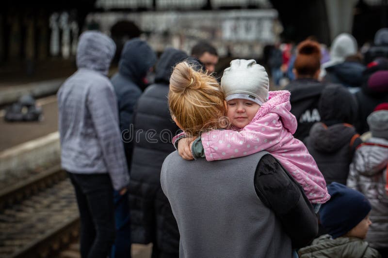 LVIV, UKRAINE - APR 02, 2022: War in Ukraine. Little girl on mom`s shoulder. Refugees from the evacuation train from Mariupol