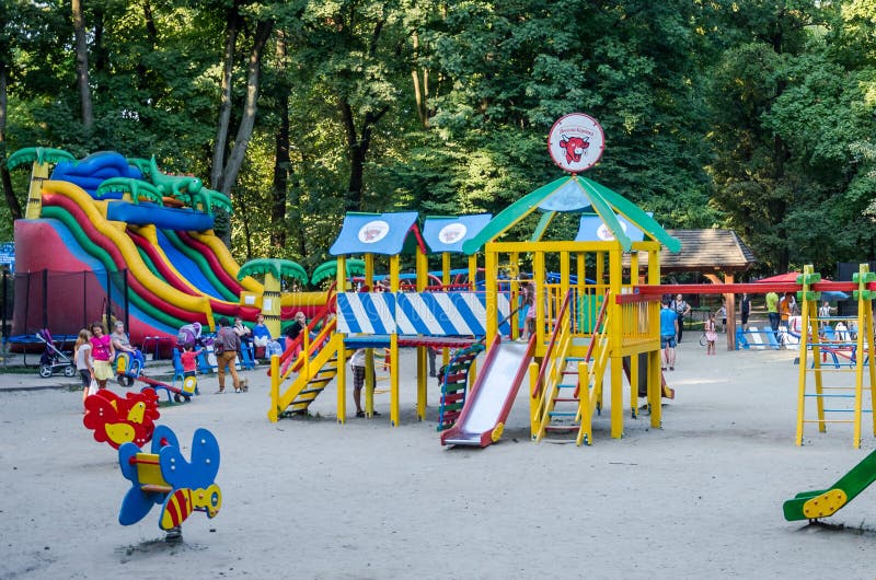 Lviv, Ukraine - 19 August 2015: Children's playground with swings and inflatable trampoline in amusement park where children play and their parents in a park in Lviv Ivan Franko