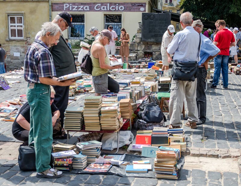Lviv, Ukraine - July 2015: Men and women choose and buy, and sellers are selling old rare books and vintage items in the book mark stock images Lviv, Ukraine - July 2015: Men and women choose and buy, and sellers are selling old rare books and vintage items in the book mark stock images