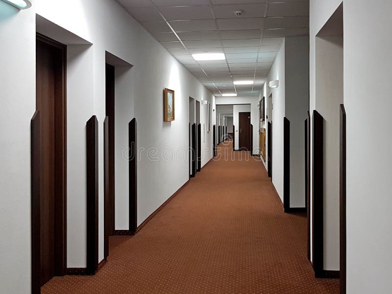 Lviv, Ukraine - 2 2 2020:Corridor in the hotel with many doors to the rooms. Interior decoration in contrast of clear and dark tones. Design of a public space. Hotel business. Safety during evacuation. Lviv, Ukraine - 2 2 2020:Corridor in the hotel with many doors to the rooms. Interior decoration in contrast of clear and dark tones. Design of a public space. Hotel business. Safety during evacuation