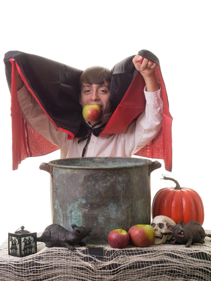 A kid enjoying an apple at a Halloween party over an apple bobbing bucket. A kid enjoying an apple at a Halloween party over an apple bobbing bucket.