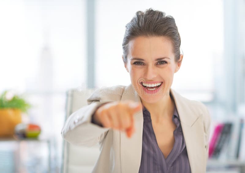 Lycklig affärskvinna i regeringsställning som in camera pekar