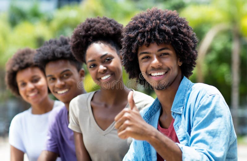 Happy african american men with group of young adults in line outdoor in city in summer. Happy african american men with group of young adults in line outdoor in city in summer