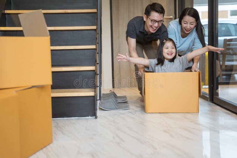 Lycklig asiatisk familj som flyttar sig till det nya huset med kartonger royaltyfri fotografi Lycklig asiatisk familj som flyttar sig till det nya huset med kartonger royaltyfri fotografi