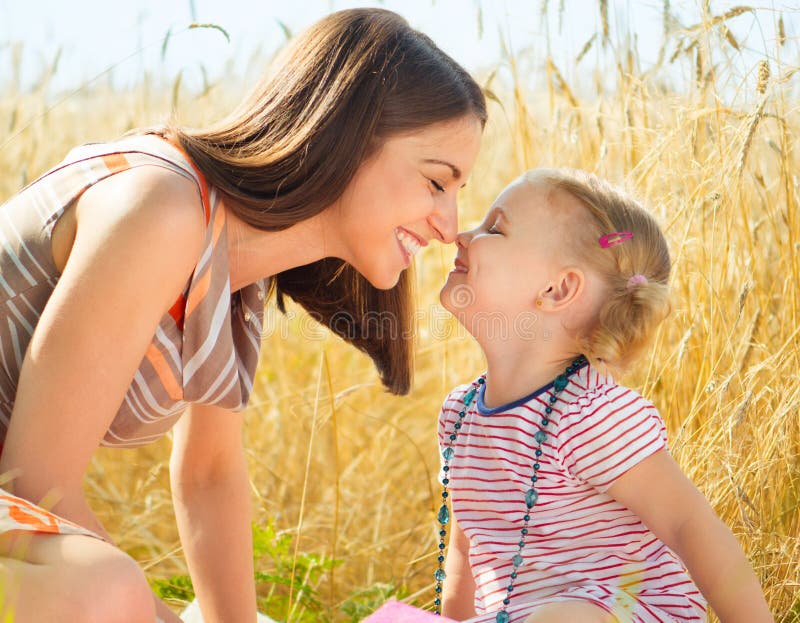 Happy young mother with little daughter having fun on wheat field in summer day. Happy young mother with little daughter having fun on wheat field in summer day