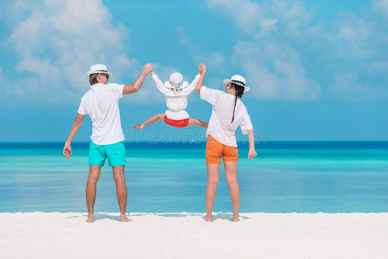 Lycklig familj av tre som hade kul tillsammans på stranden arkivfoto