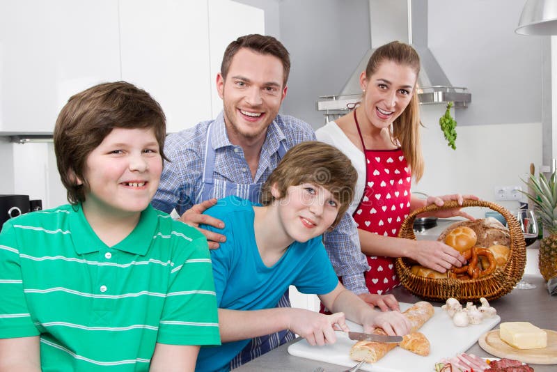Lycklig familj i köket som förbereder frukosten på söndag arkivbilder Lycklig familj i köket som förbereder frukosten på söndag arkivbilder