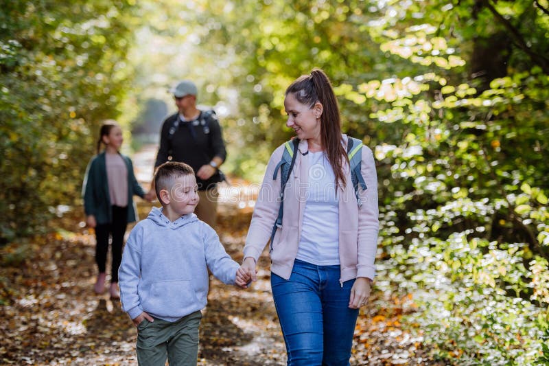 Lycklig familj med barn som går i skog. fotografering för bildbyråer