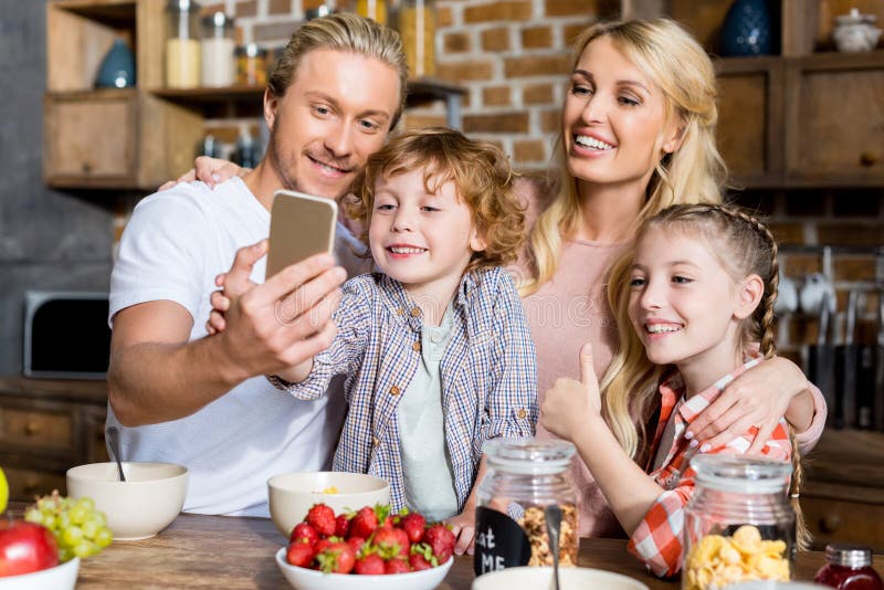 lycklig familj med två ungar som tar selfie, medan ha frukosten fotografering för bildbyråer lycklig familj med två ungar som tar selfie, medan ha frukosten fotografering för bildbyråer