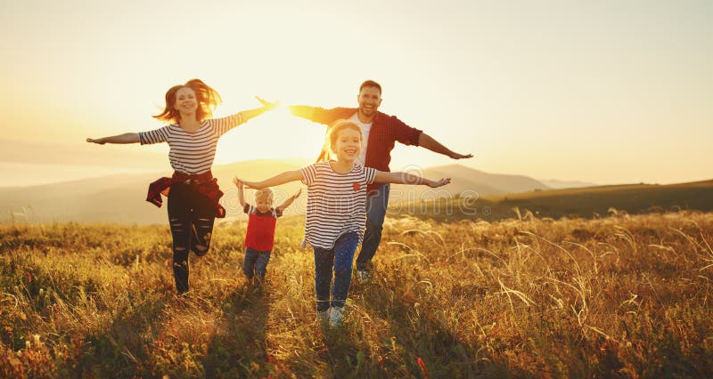 Lycklig familj: moder, fader, barn son och dotter på sunse royaltyfri bild