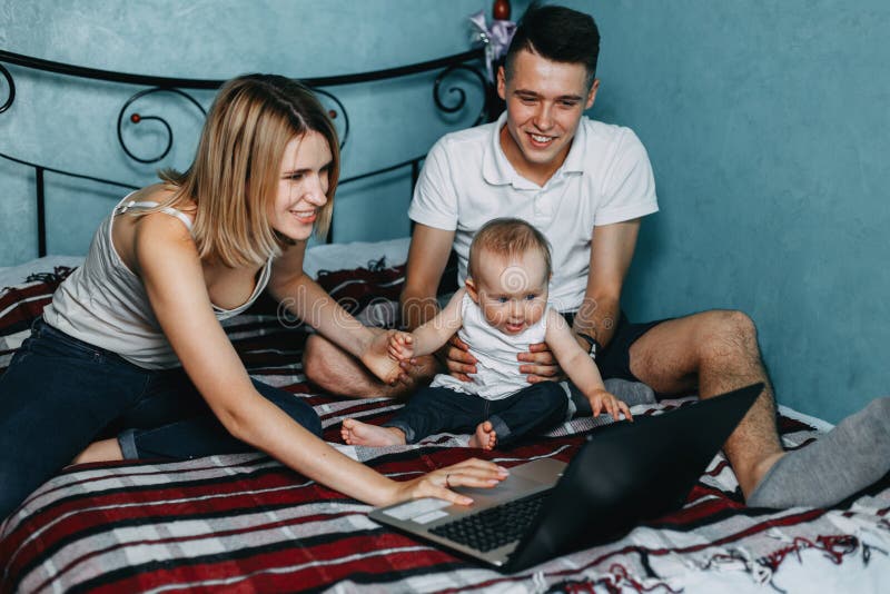 Lycklig familj som använder bärbara datorn och har gyckel royaltyfri fotografi Lycklig familj som använder bärbara datorn och har gyckel royaltyfri fotografi
