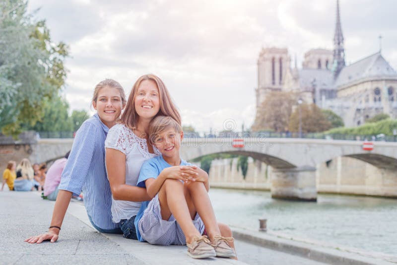 Lycklig familj som har kul nära notramekatastrofen i paris. turister som tar semester i Frankrike. royaltyfri fotografi