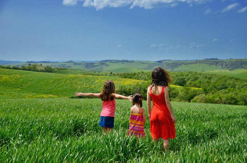 Lycklig familj som har rolig det fria på grönt fält, moder och barn på vårsemester i Tuscany, Italien royaltyfria foton Lycklig familj som har rolig det fria på grönt fält, moder och barn på vårsemester i Tuscany, Italien royaltyfria foton