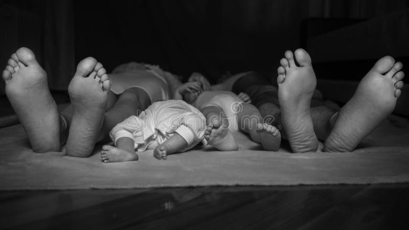 Lycklig familj som lägger på golvet, deras fot på fokus Moder, arkivfoton Lycklig familj som lägger på golvet, deras fot på fokus Moder, arkivfoton