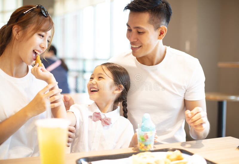 Lycklig familj som tycker om matställen i restaurang royaltyfri fotografi Lycklig familj som tycker om matställen i restaurang royaltyfri fotografi
