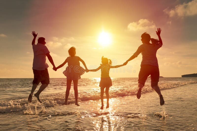 Lycklig familjbanhoppning på stranden
