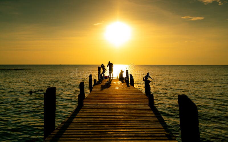 Lycklig familjlek tillsammans på sommarsemester på träbron på solnedgången Förälder och barn som spelar på stranden på ferie arkivfoto Lycklig familjlek tillsammans på sommarsemester på träbron på solnedgången Förälder och barn som spelar på stranden på ferie arkivfoto