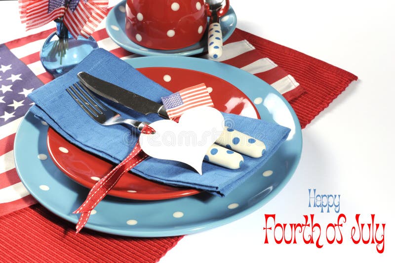 Happy Fourth of July dining table place setting in red, white and blue color theme with USA Stars and Stripes flag and heart gift tag with sample text. Happy Fourth of July dining table place setting in red, white and blue color theme with USA Stars and Stripes flag and heart gift tag with sample text.