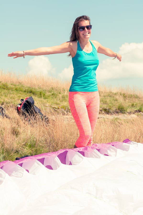 Lycklig kvinna som är klar att ta av med en paraglider arkivbild Lycklig kvinna som är klar att ta av med en paraglider arkivbild