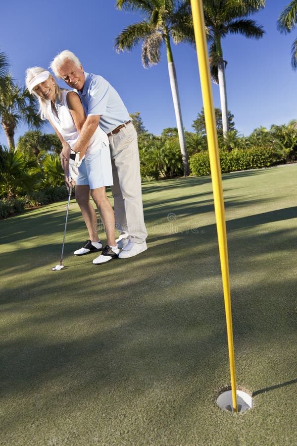 lycklig leka sättande pensionär för pargolf arkivfoto lycklig leka sättande pensionär för pargolf arkivfoto