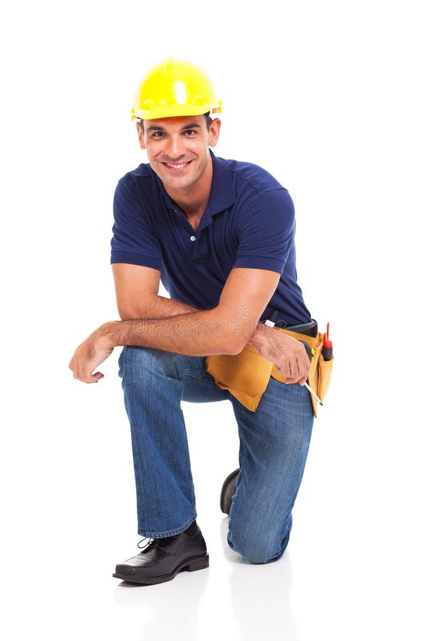 Happy male constructor kneeling over white background. Happy male constructor kneeling over white background