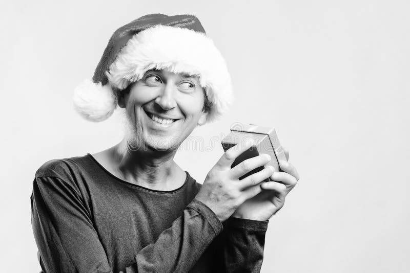 Lycklig man i santa hjälpredahattar med gåvaasken Vinterferier och julbegrepp Uppackning av gåvan Isolat på vit joyful santa royaltyfri foto Lycklig man i santa hjälpredahattar med gåvaasken Vinterferier och julbegrepp Uppackning av gåvan Isolat på vit joyful santa royaltyfri foto