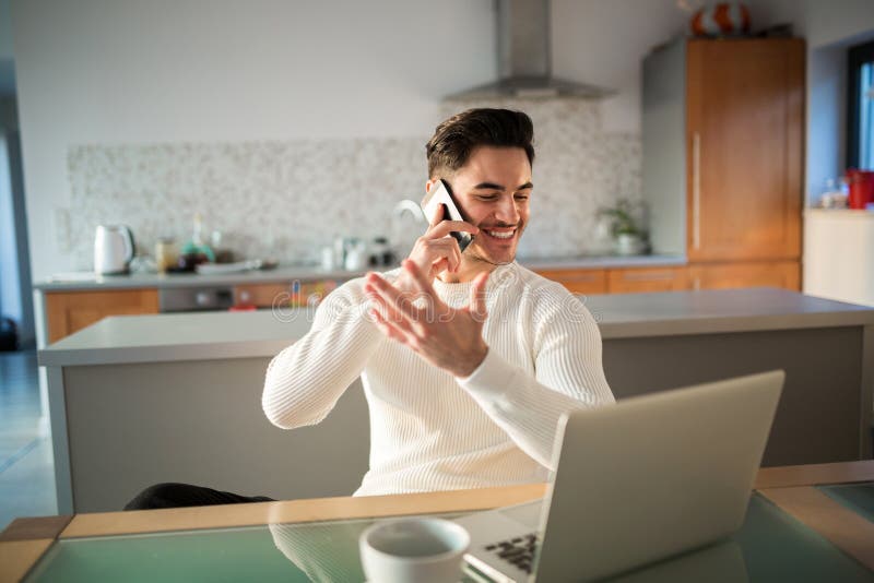 Lycklig man som hemma arbetar samtal på mobil royaltyfri bild Lycklig man som hemma arbetar samtal på mobil royaltyfri bild