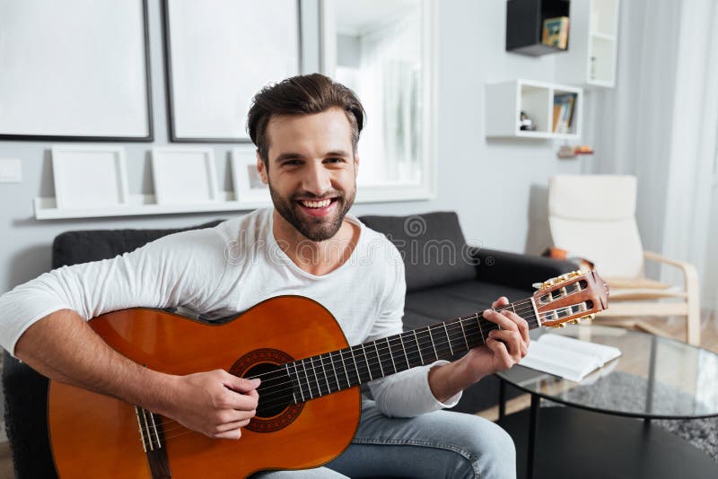 Lycklig man som spelar på gitarren se kameran arkivbilder Lycklig man som spelar på gitarren se kameran arkivbilder