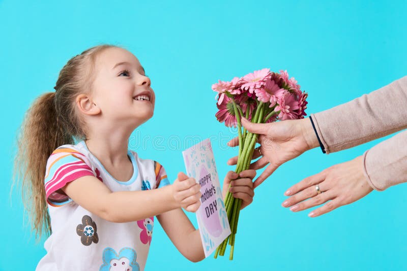 lycklig moder s för dag Gullig liten flicka som ger mammahälsningkortet och buketten av rosa gerberatusenskönor Fostra och dotter arkivbilder lycklig moder s för dag Gullig liten flicka som ger mammahälsningkortet och buketten av rosa gerberatusenskönor Fostra och dotter arkivbilder