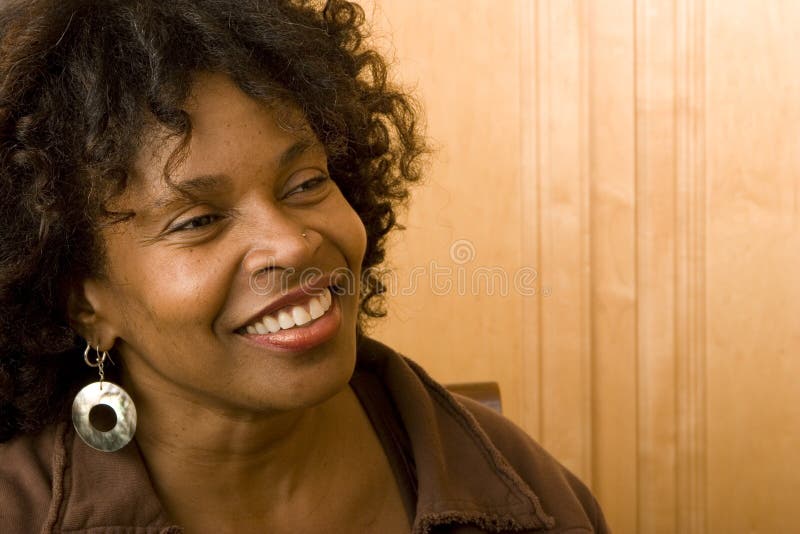Lycklig mogen afrikansk amerikankvinna som hemma ler