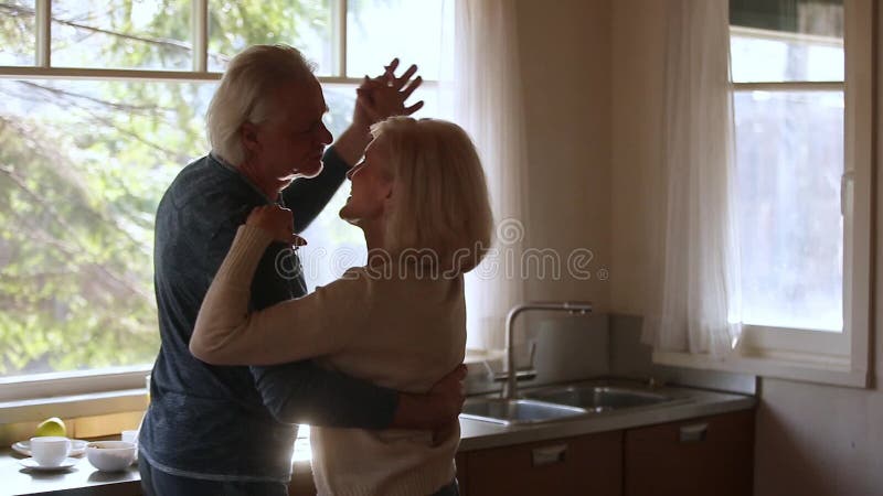 Lycklig mogen hög pardans som skrattar i köket stock video