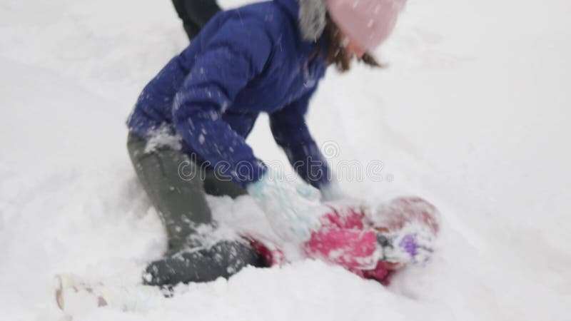 Lycklig mor och dotter leker med snö