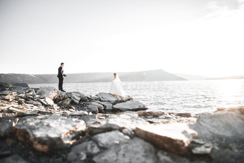 Lycklig och romantisk plats av precis gifta unga brölloppar som poserar på den härliga stranden arkivfoton Lycklig och romantisk plats av precis gifta unga brölloppar som poserar på den härliga stranden arkivfoton