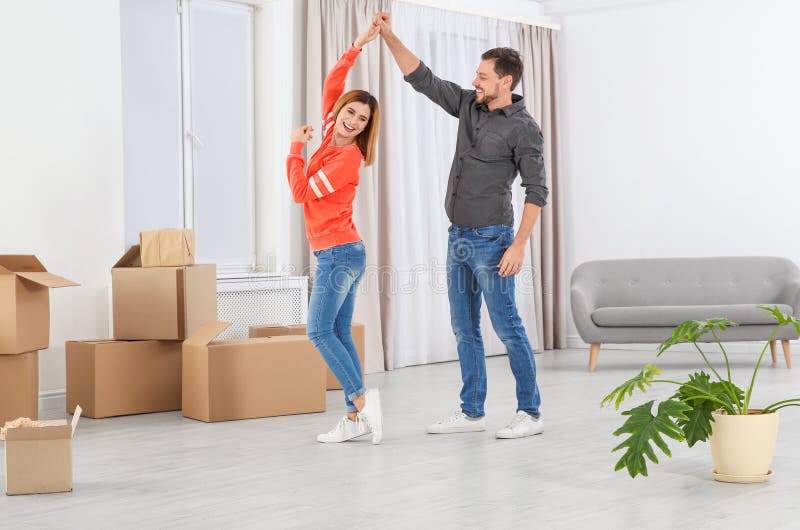 Lycklig pardans nära rörande askar i nytt hus arkivbild Lycklig pardans nära rörande askar i nytt hus arkivbild