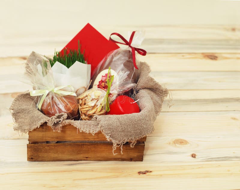 Lycklig påsk, träask med gåvor, stearinljusägg, påskkaka, choklader och grönt gräs kopiera avstånd royaltyfri bild Lycklig påsk, träask med gåvor, stearinljusägg, påskkaka, choklader och grönt gräs kopiera avstånd royaltyfri bild