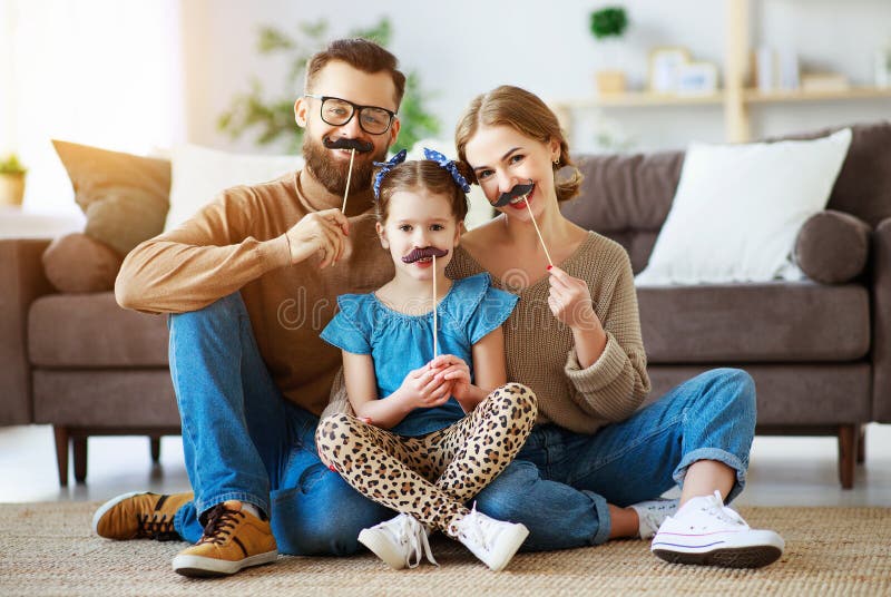 Lycklig rolig familjmoderfader och barndotter med mustaschen p? pinnen arkivbild Lycklig rolig familjmoderfader och barndotter med mustaschen p? pinnen arkivbild