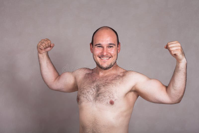 Lycklig shirtless man som poserar och visar hans starka kropp arkivfoton Lycklig shirtless man som poserar och visar hans starka kropp arkivfoton