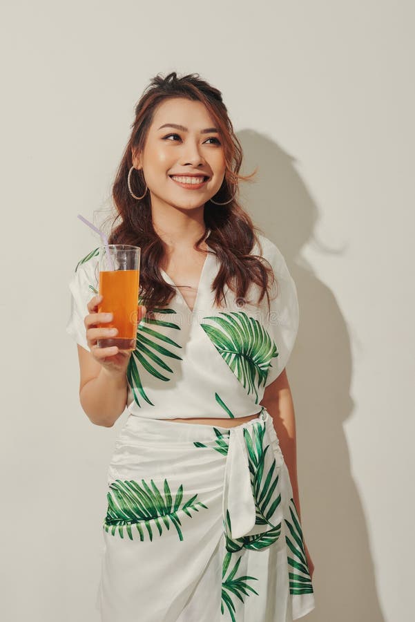 Lycklig som kvinna på sommarfriska kläder med ett glas färsk fruktjuicedryck royaltyfri foto