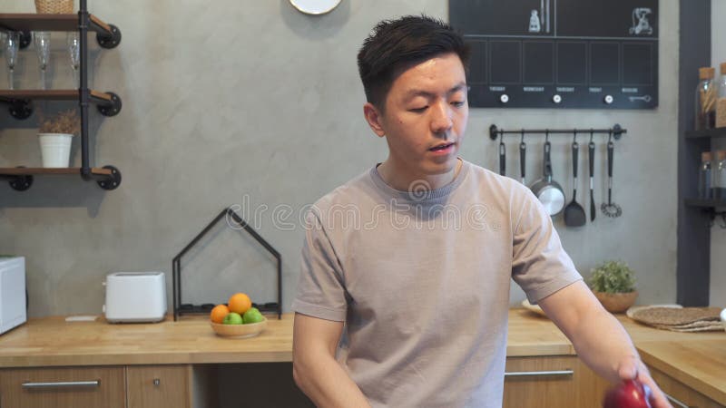 Lycklig stilig asiatisk ung man som dricker en kopp kaffe lager videofilmer