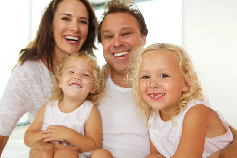 Lycklig ung familj som tillsammans hemma sitter fotografering för bildbyråer Lycklig ung familj som tillsammans hemma sitter fotografering för bildbyråer