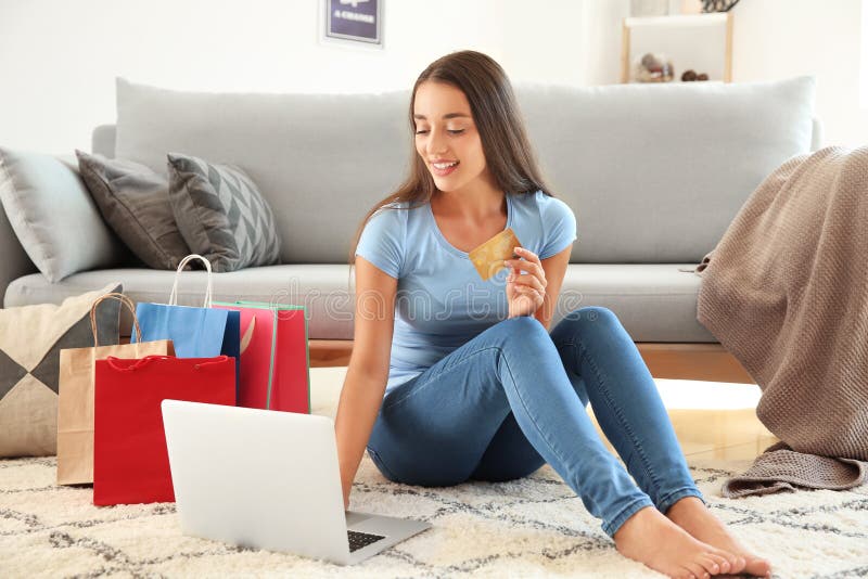 Lycklig ung kvinna efter online-shopping hemma arkivbild Lycklig ung kvinna efter online-shopping hemma arkivbild