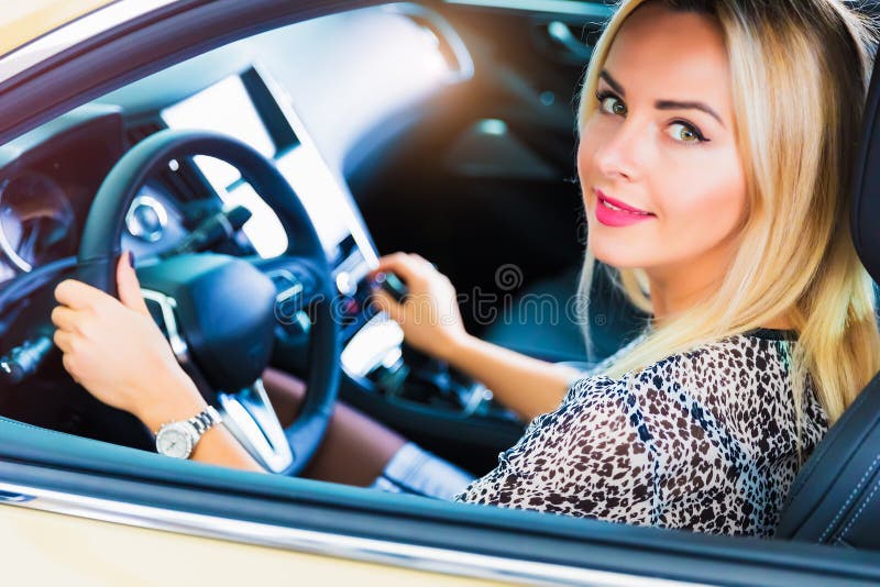 Lycklig ung kvinna i den moderna lyxiga bilen fotografering för bildbyråer