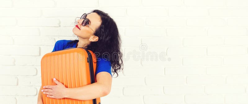 Lycklig ung kvinna som rymmer den orange resväskan som går på en tur Bärande solglasögon för härlig flicka, innan att resa Livsst arkivbilder Lycklig ung kvinna som rymmer den orange resväskan som går på en tur Bärande solglasögon för härlig flicka, innan att resa Livsst arkivbilder