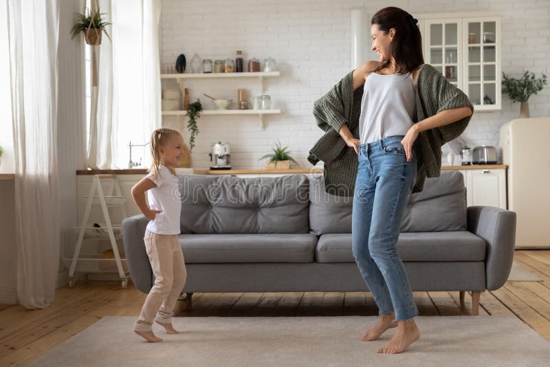 Lycklig ung mamma och liten dotter som dansar kul royaltyfri bild