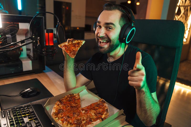 Lycklig ung man på headset med dator arkivbild