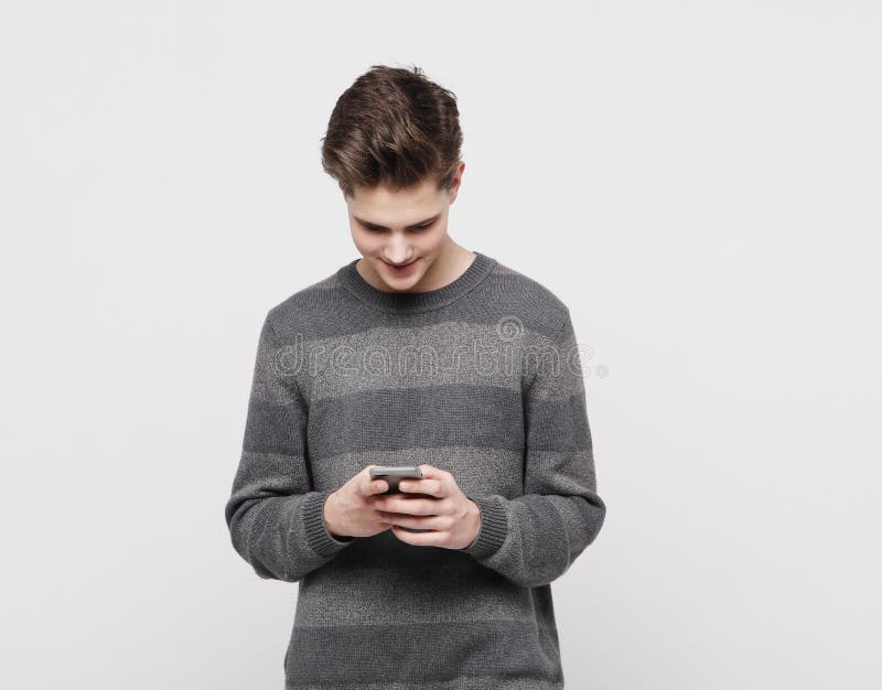 Lycklig ung man som skriver sms på vit bakgrund royaltyfria bilder Lycklig ung man som skriver sms på vit bakgrund royaltyfria bilder