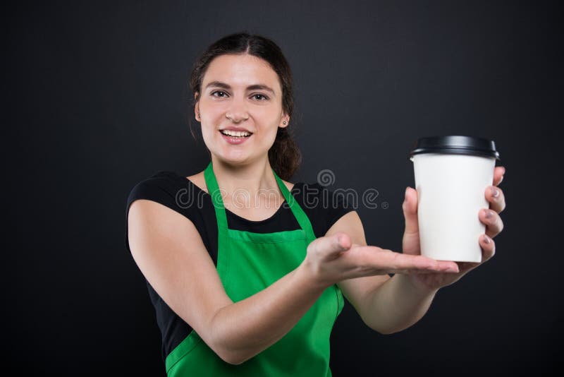 Lycklig ung säljare som erbjuder ett disponibelt kaffe royaltyfria foton Lycklig ung säljare som erbjuder ett disponibelt kaffe royaltyfria foton