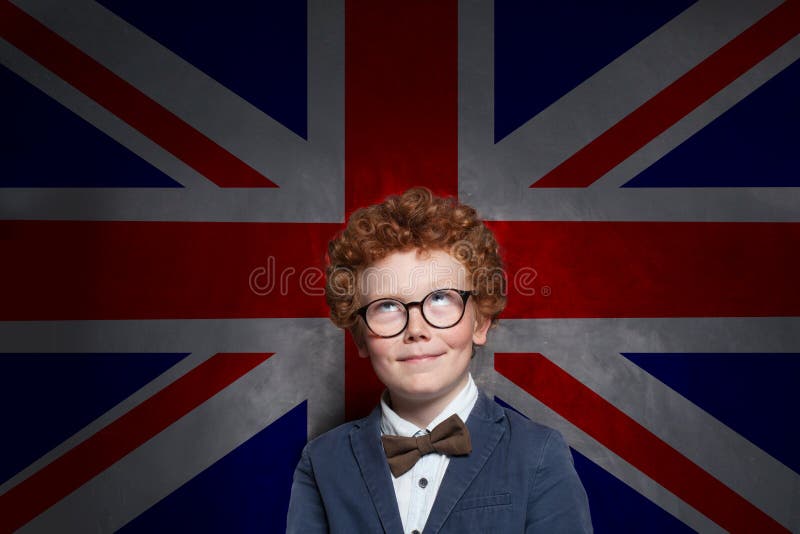 Happy child boy english studen looking up on the UK flag background. Learn English concept. Happy child boy english studen looking up on the UK flag background. Learn English concept.