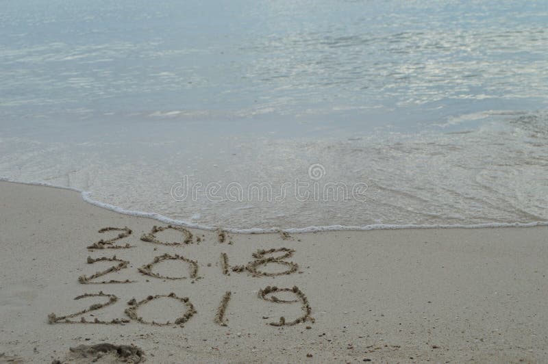 Lyckliga nya år 2017, 2018 och 2019 som är handskrivna på sand royaltyfri foto Lyckliga nya år 2017, 2018 och 2019 som är handskrivna på sand royaltyfri foto
